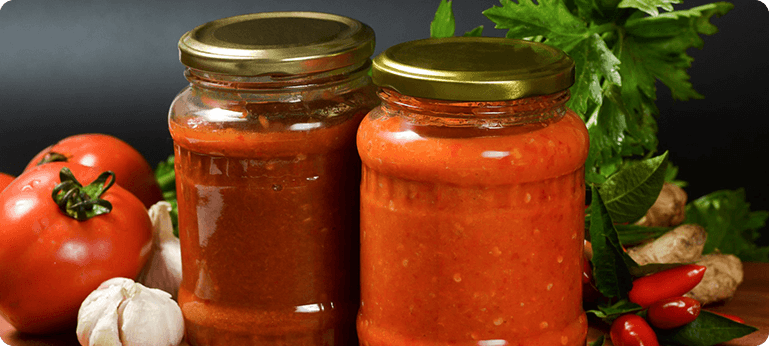 Two jars of tomato sauce and a plant.